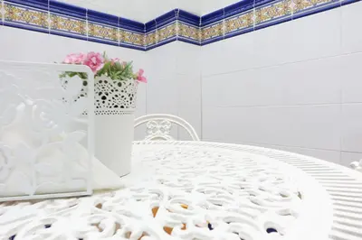 a kitchen with wooden cabinets and a stainless steel refrigerator at Best Valencia Beach Rooms-Shared Flat in Valencia
