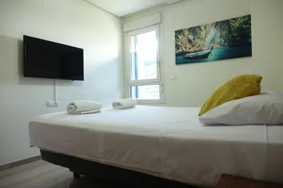 a bedroom with a large bed with towels on it at Best Valencia Beach Rooms-Shared Flat in Valencia
