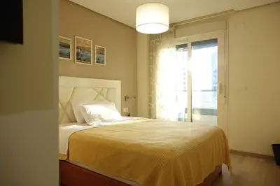 a bedroom with a bed with a white bedspread at Best Valencia Beach Rooms-Shared Flat in Valencia