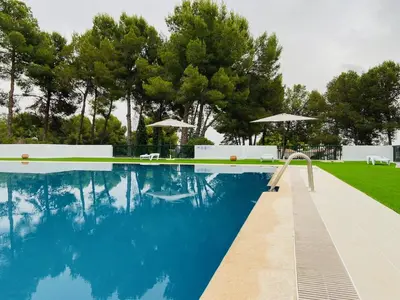 a swimming pool with chairs and umbrellas at Casa Mayor in Tous