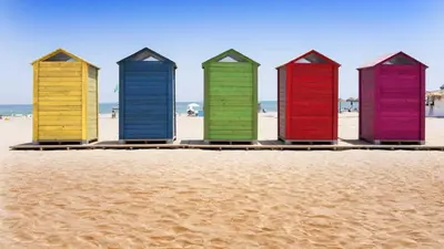 a row of colorful beach huts on the beach at BEACH VALENCIA LUXURY A40-13 Apartment with terrace and sea views in Valencia
