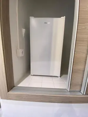 a small white refrigerator in a room at Apartamento Casa Anselmo La cambra in Losa del Obispo