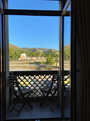 a balcony with two chairs and a view of the mountains at Apartamento Casa Anselmo La cambra in Losa del Obispo