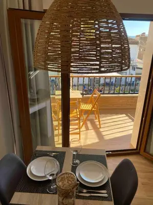 a dining room table with a chandelier and a view of a balcony at Apartamentos LOSA RURAL in Losa del Obispo