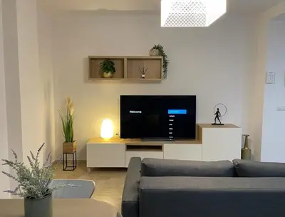 a living room with a couch and a flat screen tv at UIM Mediterraneo PB Felipe 2 Wifi in Puerto de Sagunto