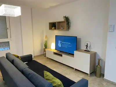 a living room with a couch and a flat screen tv at UIM Mediterraneo PB Felipe 2 Wifi in Puerto de Sagunto