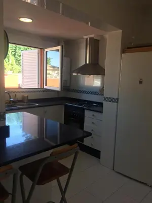 a dining room with a table and chairs and a window at Casa buganvilla in Almarda