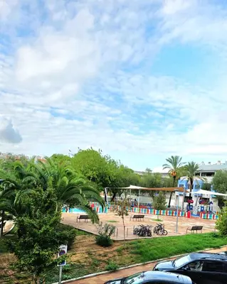a view of a park with a pool and palm trees at Entire Apartment near Valencia - 2 Bedrooms & 2 Bathrooms in Paterna