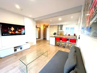 a living room with a couch and a tv on a wall at Puerto Playa Paradise in Puerto de Sagunto