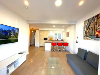 a living room with a couch and red chairs at Puerto Playa Paradise in Puerto de Sagunto