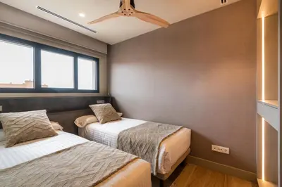 a bedroom with two beds and a ceiling fan at Apartamentos Core Suites Valencia in Valencia