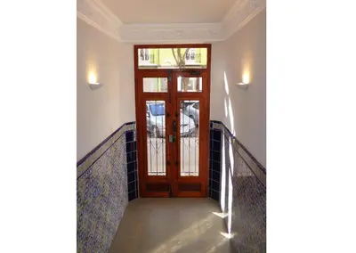 a hallway with a wooden door and a railing at Classic City Apartment in Valencia