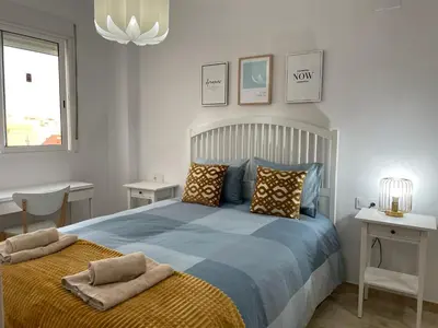 a bedroom with a large blue bed with pillows at UIM Mediterraneo ATICO Felipe Wifi in Puerto de Sagunto