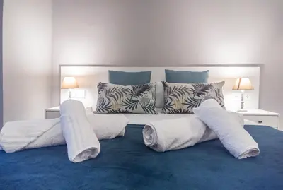 a large bed with white sheets and pillows on it at City Hall Central Market in Valencia