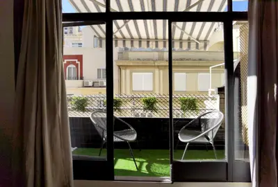 a room with a window with two chairs on a balcony at City Hall Central Market in Valencia