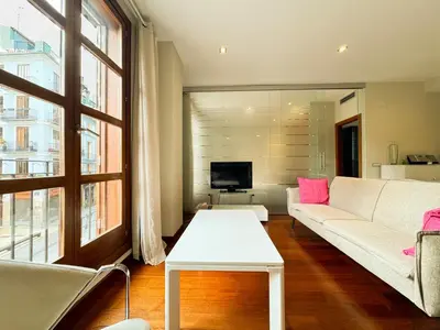 a living room with a white couch and a tv at Precioso Apartamento en la Plaza del Tossal in Valencia