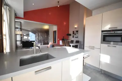 a kitchen with a sink and a red wall at Bello Apartamento en la Plaza del Tossal in Valencia