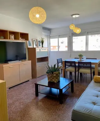 a living room with a couch and a tv and a table at UIM Mediterraneo Diagonal 16 Wfi in Puerto de Sagunto