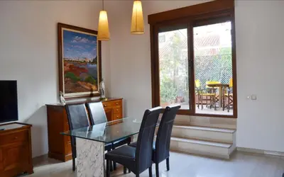 a dining room with a glass table and chairs at Valencia Green Penthouse in Valencia