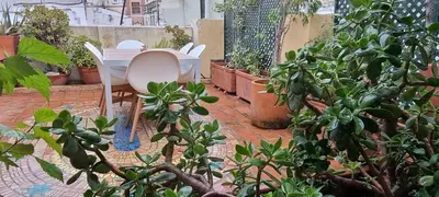 a patio with a table and chairs and potted plants at Valencia Green Penthouse in Valencia