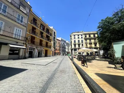 an empty street in a city with buildings at Moderno Apartamento en la Plaza del Tossal in Valencia
