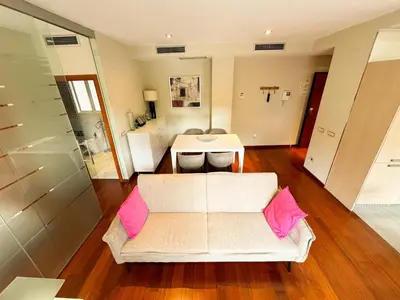 a living room with a white couch and pink pillows at Moderno Apartamento en la Plaza del Tossal in Valencia