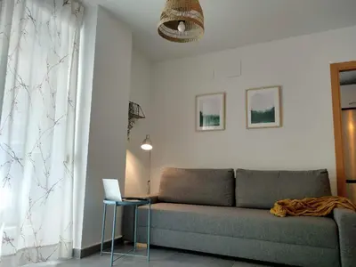 a living room with a couch and a laptop on a table at Apartamento acogedor en playa de Moncofa in Moncófar