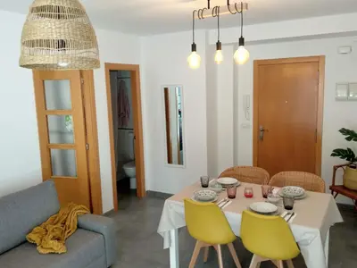 a dining room with a table and yellow chairs at Apartamento acogedor en playa de Moncofa in Moncófar
