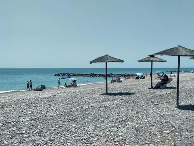 people on a beach with umbrellas and the ocean at Apartamento acogedor en playa de Moncofa in Moncófar