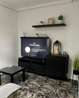 a living room with a flat screen tv on a stand at UIM Mediterraneo Juana Wifi in Puerto de Sagunto