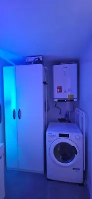 a laundry room with a white washer and a blue light at A7 ViviendaTuristicaValencia Arte in Valencia
