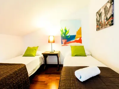 a room with two beds and a table with a lamp at Total Valencia (Leisure & Culture) in Valencia