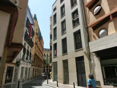 a person walking down a street between two buildings at Total Valencia (Leisure & Culture) in Valencia