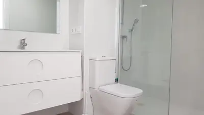 a white bathroom with a toilet and a shower at Studio Picasso near the port and beach in Valencia
