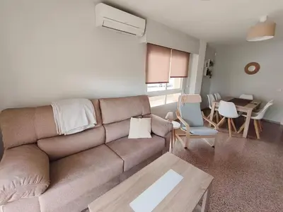 a living room with a couch and a table at Las Olas Solo Familias Serviplaya in Casas Las Basas