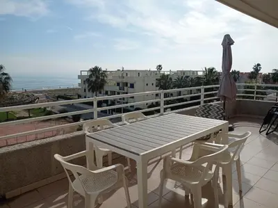 two tall buildings with a palm tree in front of them at Las Olas Solo Familias Serviplaya in Casas Las Basas