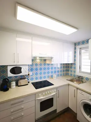 a kitchen with white cabinets and a stove top oven at Precioso apartamento residencial con vistas al mar in Puebla de Farnals