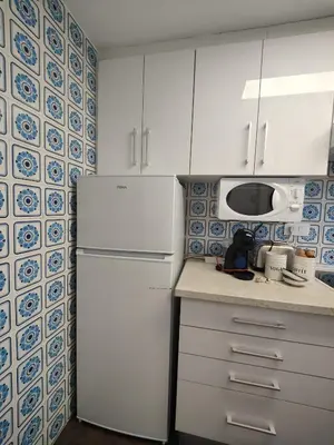 a kitchen with a white refrigerator and a microwave at Precioso apartamento residencial con vistas al mar in Puebla de Farnals