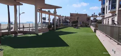 a balcony with green grass next to a beach at Sunny&Beach in Valencia in Valencia