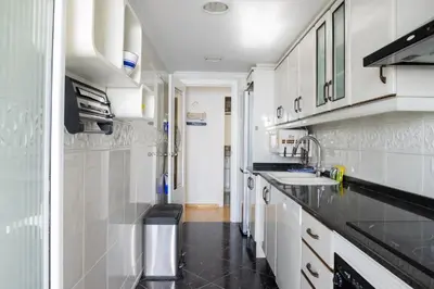 a kitchen with white cabinets and black counter tops at Platja Puig in Valencia