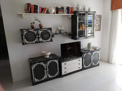 a living room with black and white furniture and a tv at Les Motes Solo Familias Serviplaya!!! in Playa de Xeraco