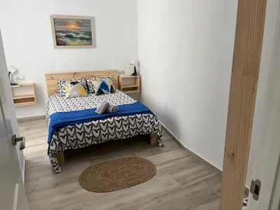 a bedroom with a bed with a blue and white comforter at Alzira bonita Apartamento D junto a Plaza Mayor, Santa Catalina in Alzira