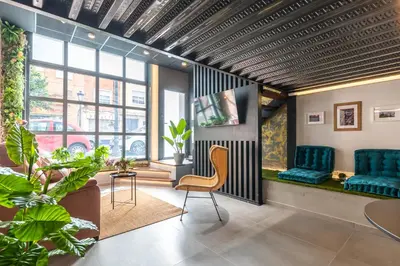 a waiting room with blue chairs and a table at Encantador Loft a un Paso del Río Turia in Valencia