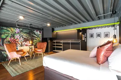 a bedroom with a bed and a table and chairs at Encantador Loft a un Paso del Río Turia in Valencia