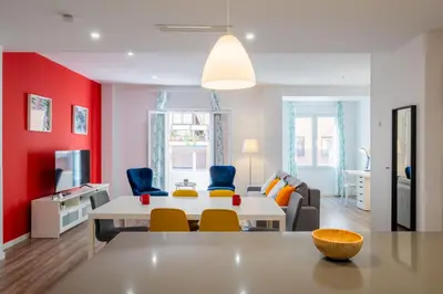 a living room with a white table and blue chairs at Spacious & Clean Apartment in Quiet Area in Valencia