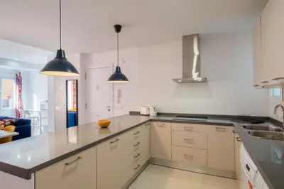 a kitchen with white cabinets and black counter tops at Spacious Clean & Colorful Apt Quiet Zone in Valencia