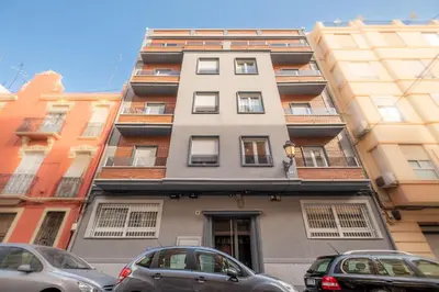 a tall building with cars parked in front of it at Spacious Clean & Colorful Apt Quiet Zone in Valencia