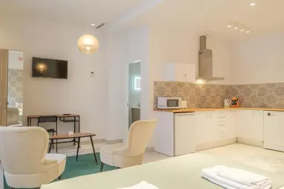 a kitchen with white cabinets and chairs and a table at Gorgeous Apartment close to City Centre in Valencia