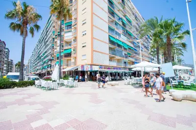 a group of people walking on a sidewalk in front of a building at PRIMERISIMA LINEA DE PLAYA - CULLERA BAHIA DE LOS NARANJOS I in Cullera