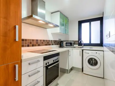 a kitchen with white cabinets and a washer and dryer at Apartment Porte Venere by Interhome in Moncófar